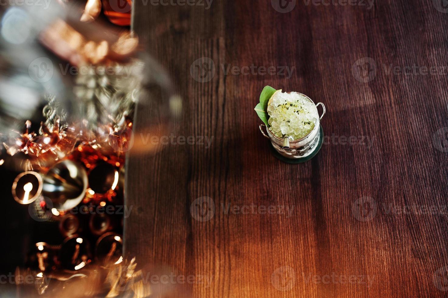 coquetel alcoólico com gelo em vidro de lata na mesa do bar. foto