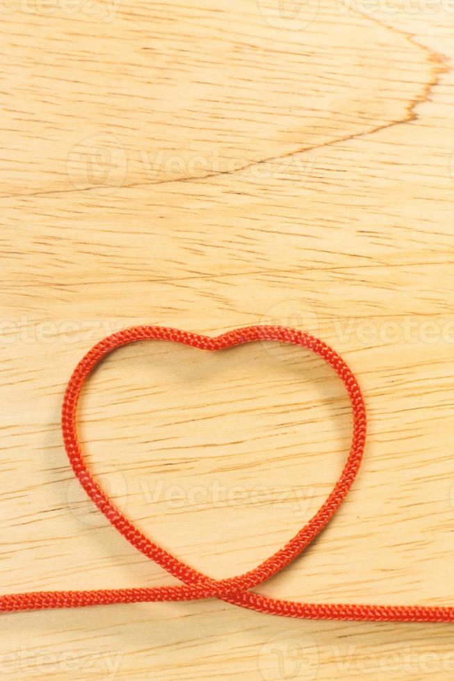 coração de corda vermelha no conteúdo de dia dos namorados de placa de madeira. foto