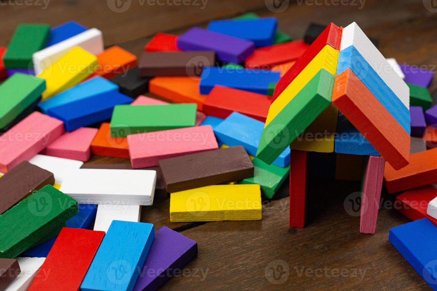 a casa de construção multicolor do domino na imagem da mesa de madeira. foto