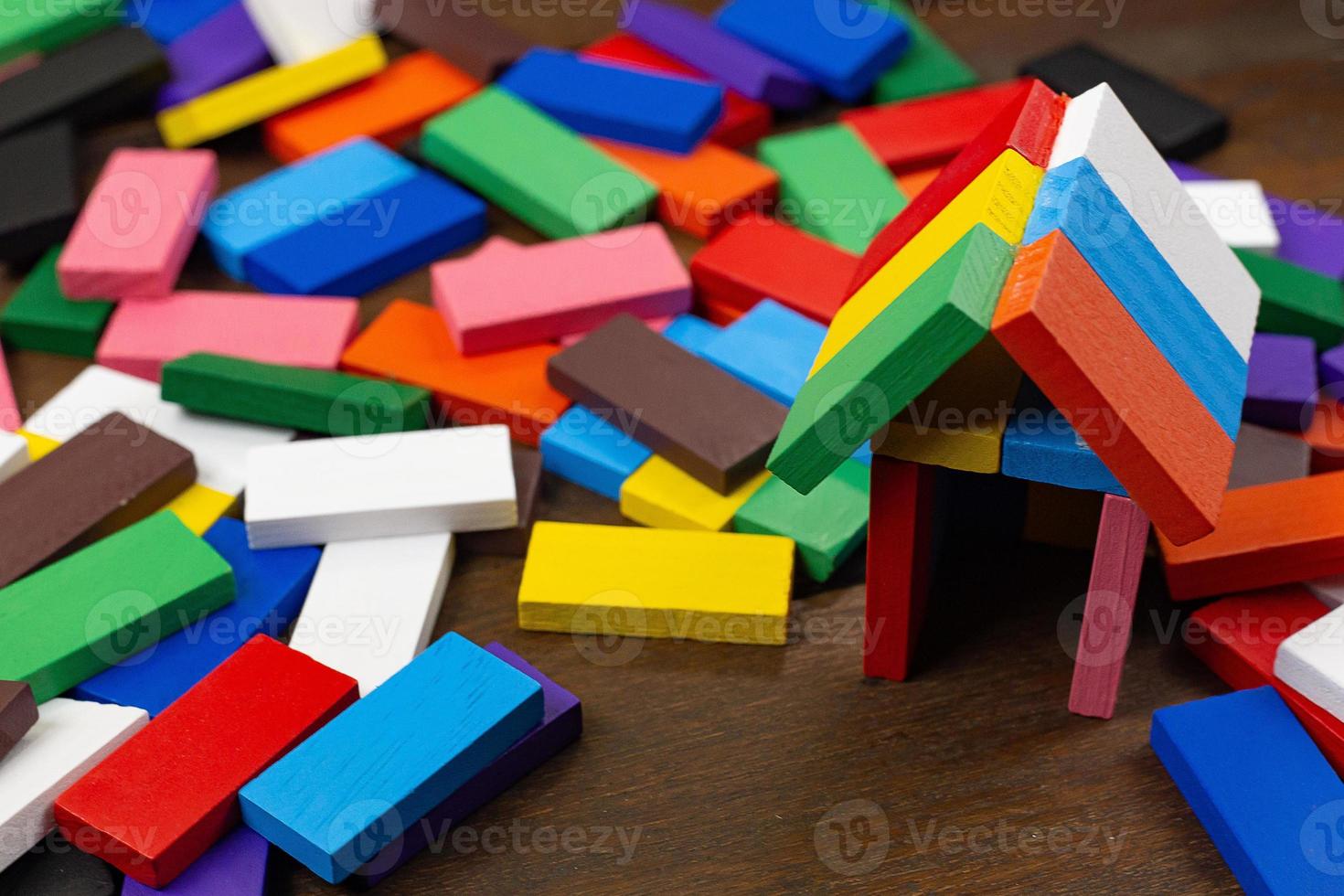 a casa de construção multicolor do domino na imagem da mesa de madeira. foto