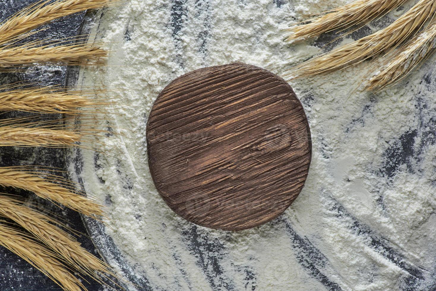 espiga de trigo, farinha de trigo e tábua de corte em fundo de madeira, vista superior. foto com espaço de cópia.
