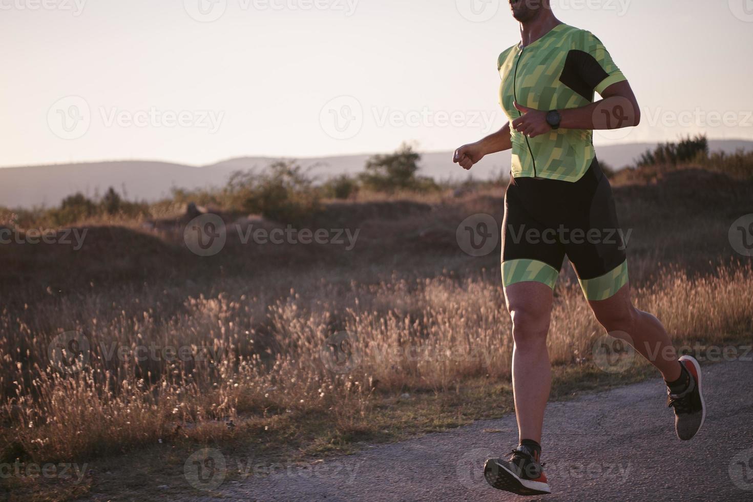 atleta de triatlo correndo no treino matinal foto