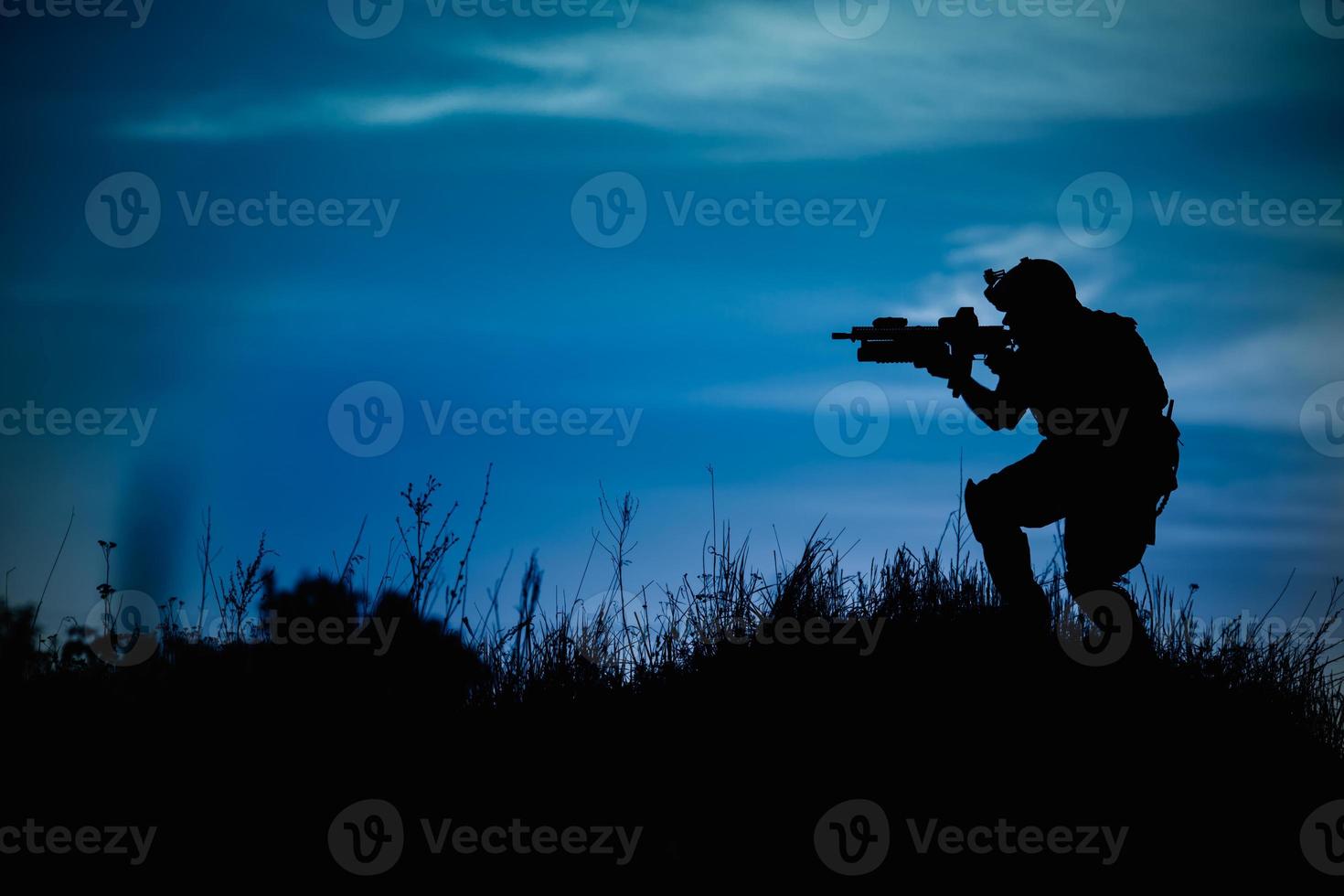 silhueta de soldado militar ou oficial com armas à noite. foto