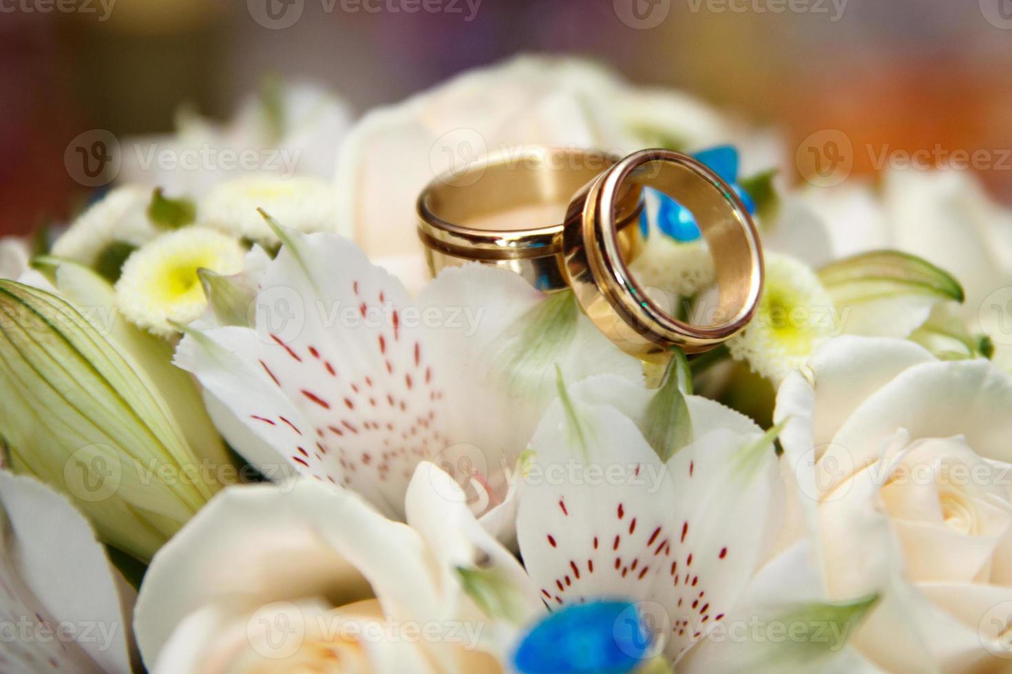 buquê de casamento brilhante de flores de verão com anéis de casamento foto