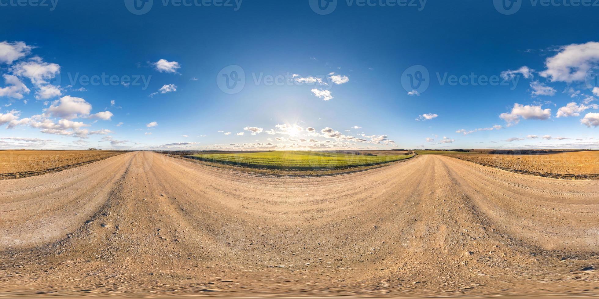 panorama esférico sem costura visão de ângulo de 360 graus em estrada de cascalho sem tráfego entre campos na noite antes do pôr do sol com céu claro em projeção equirretangular, conteúdo vr ar foto