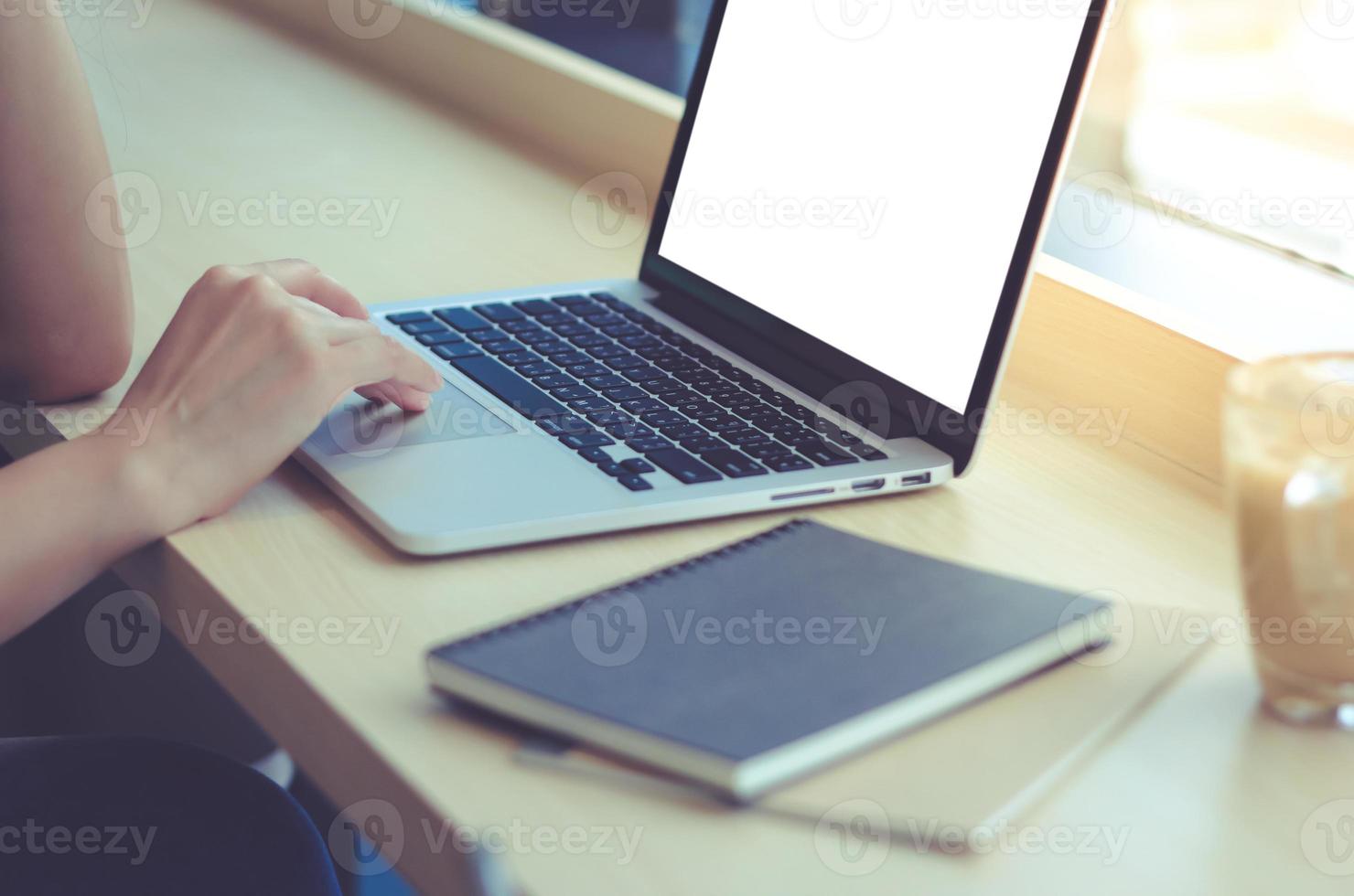 close-up da jovem empresária digitando no laptop do computador com tela em branco no escritório ou café, negócios e conceito de maquete foto