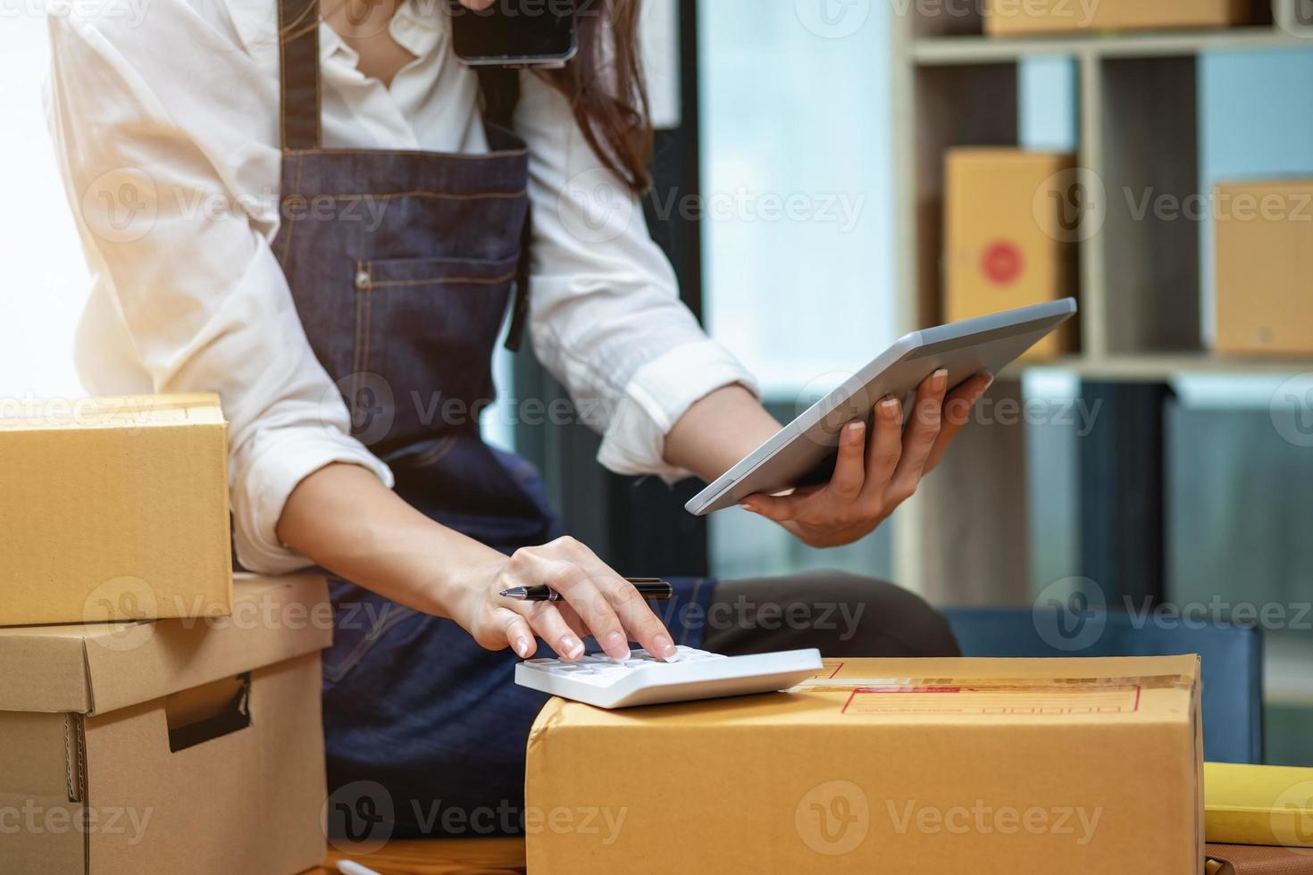 jovem empresária usando um tablet para verificar as vendas de produtos online foto