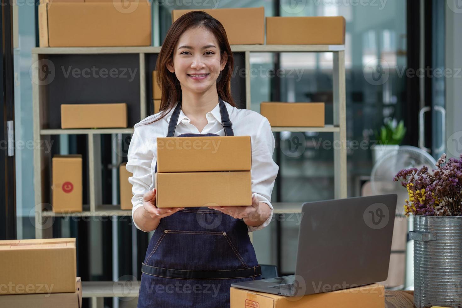 Dona de uma empresa de vendas on-line recebe pedidos e entrega produtos com caixas aos clientes. conceito de negócio on-line sme foto