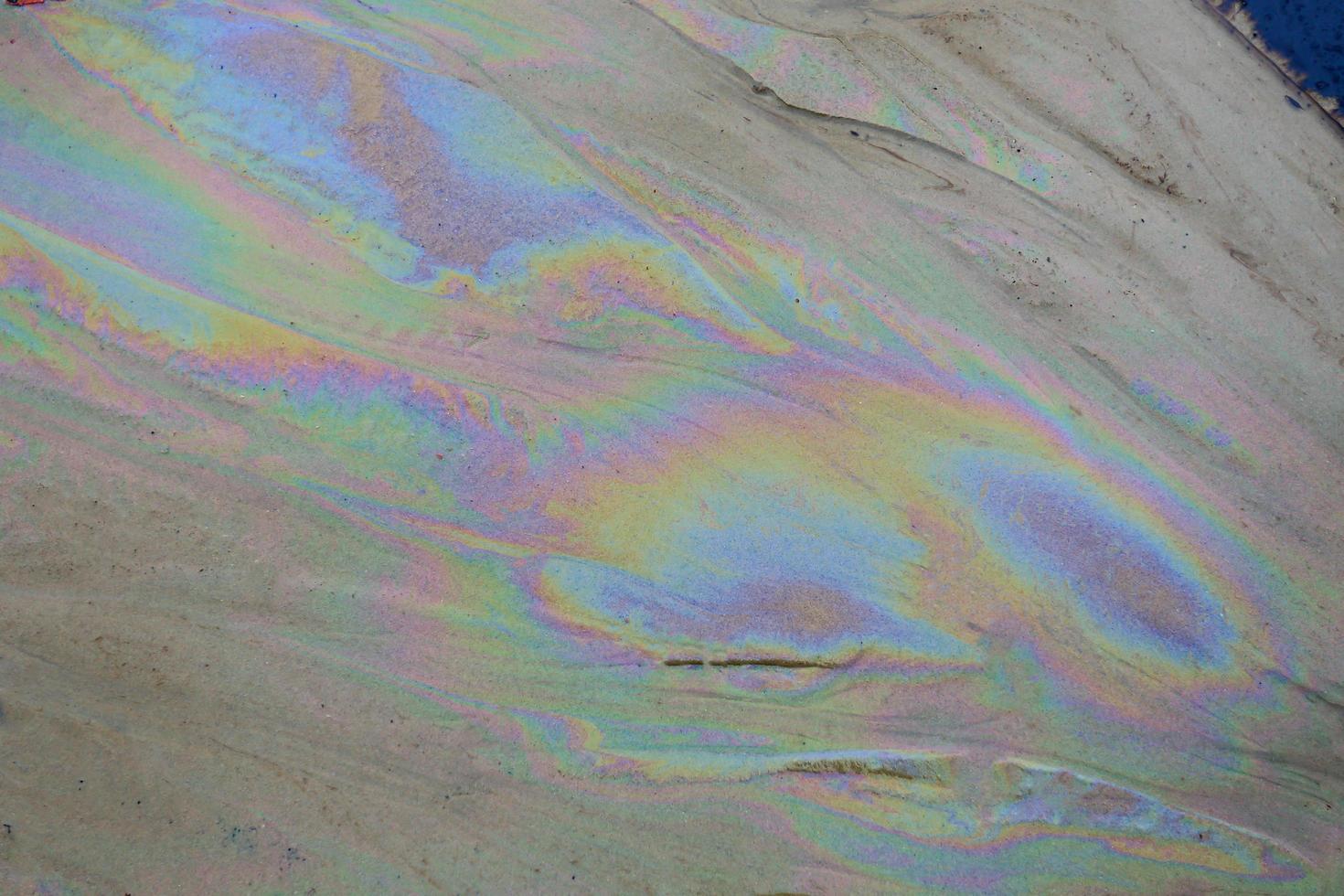 petróleo bruto na água do mar e reflexão do arco-íris foto