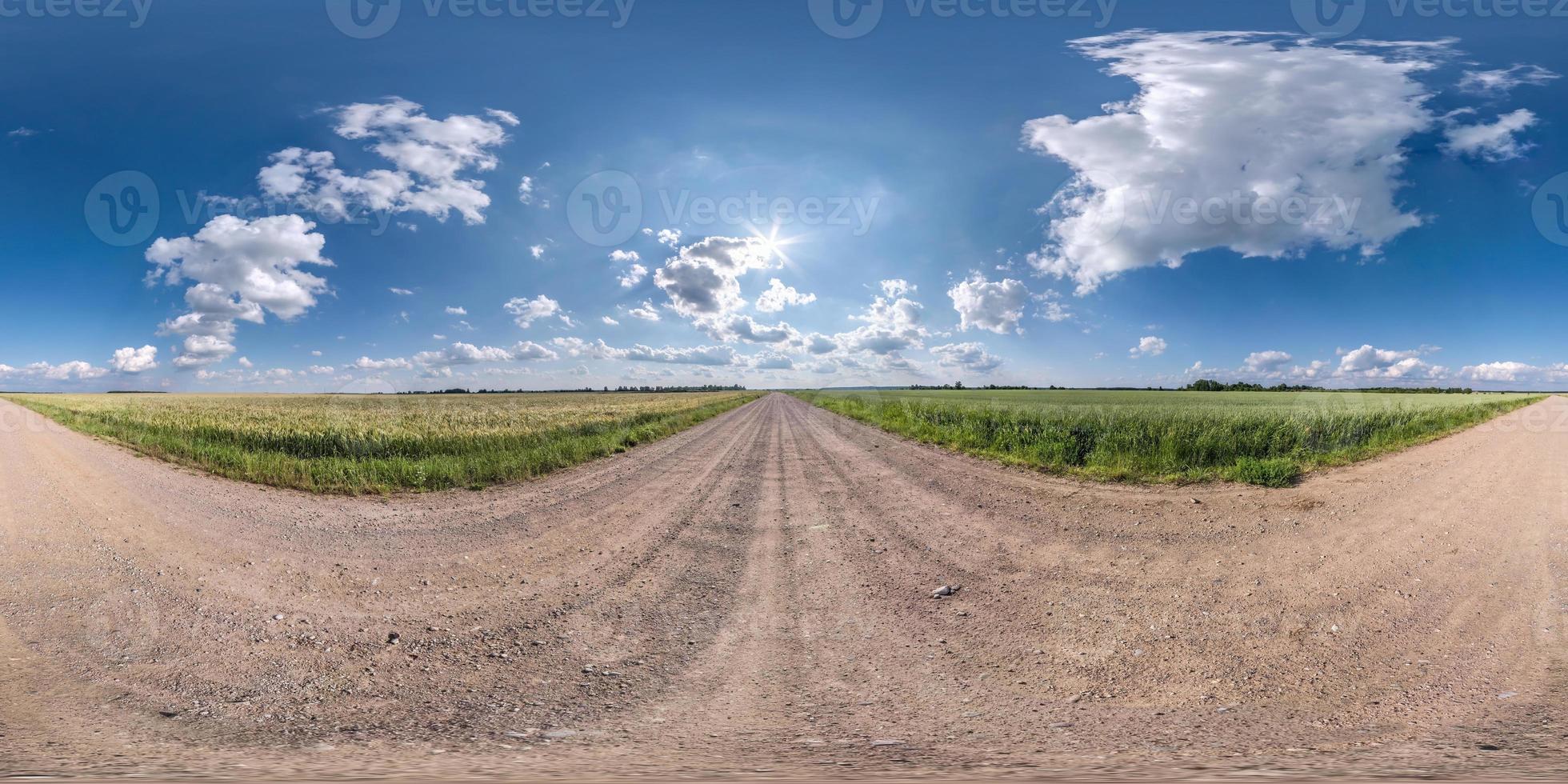 panorama hdri sem costura esférico completo vista de ângulo de 360 graus em estrada de cascalho de areia branca sem tráfego entre campos com céu claro com belas nuvens em projeção equirretangular, conteúdo vr ar foto