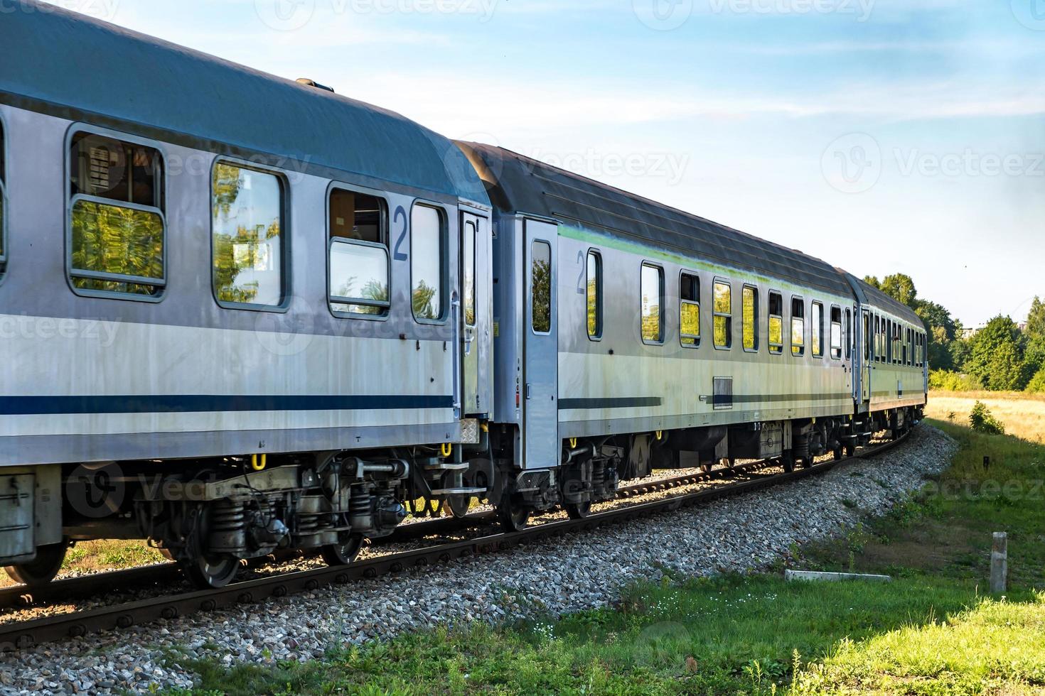 passeios de trem de passageiros entre campos em um dia ensolarado foto