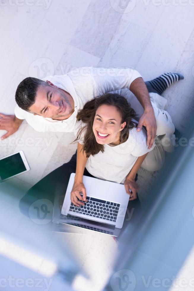 casal usando tablet e laptop vista superior foto