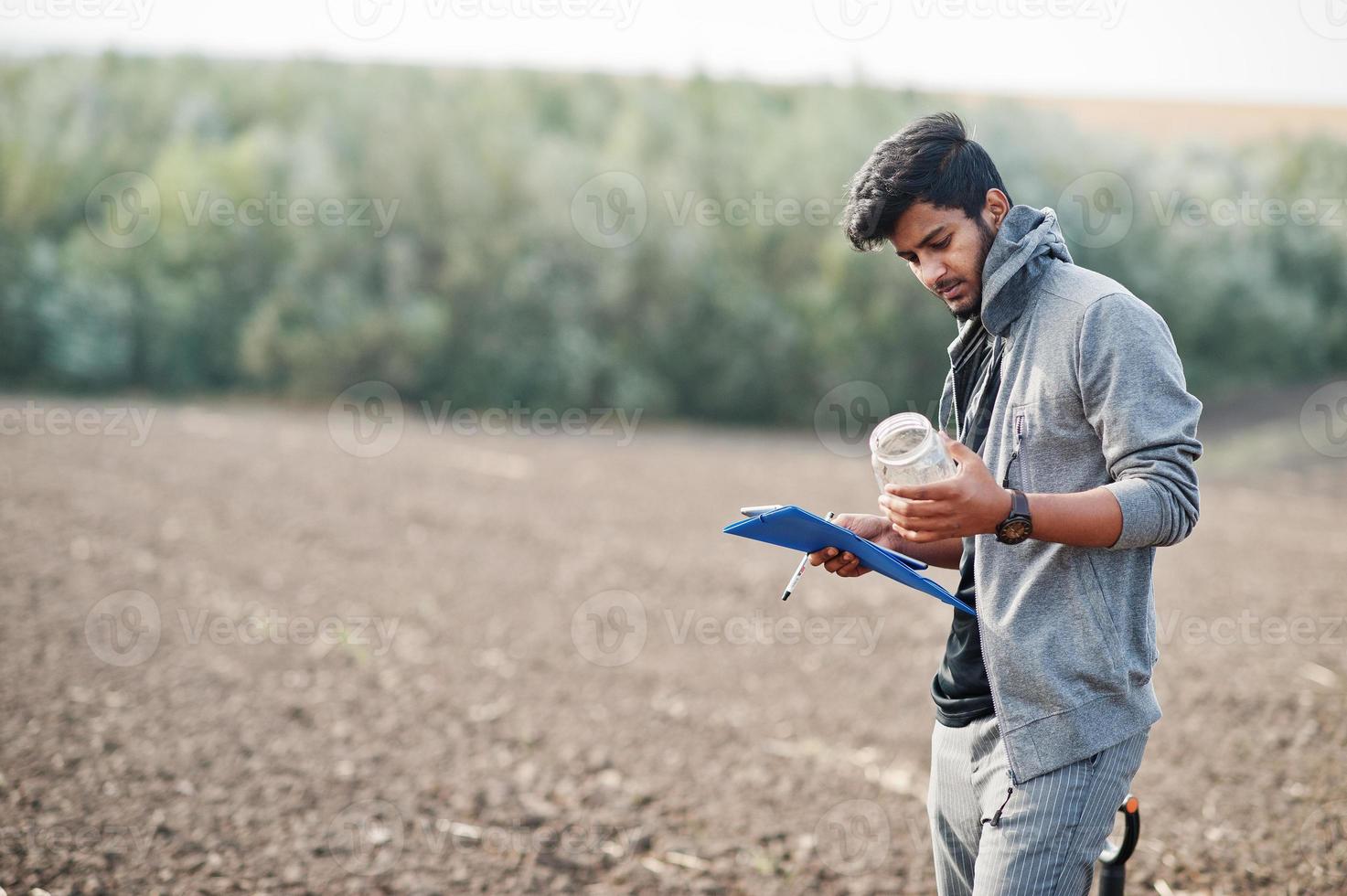agricultor agrônomo do sul da Ásia com pá inspecionando o solo preto. conceito de produção agrícola. foto