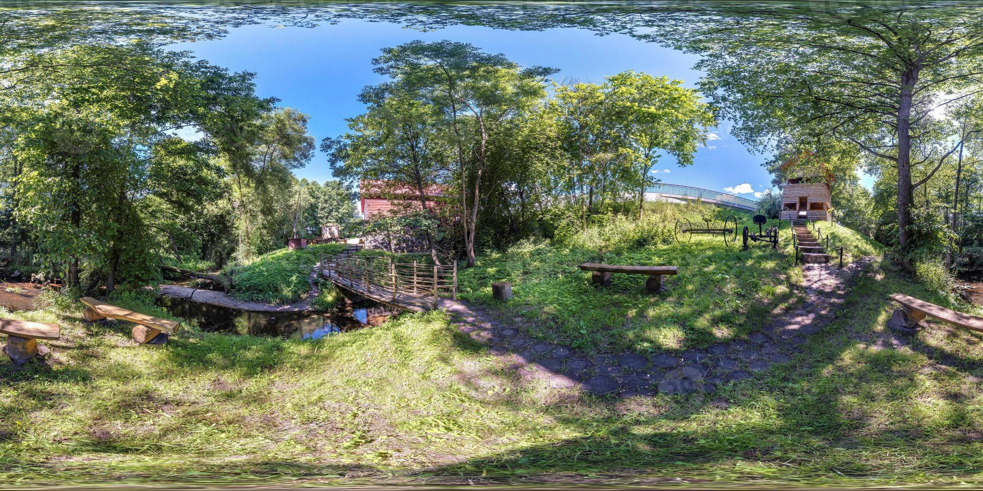 panorama hdri esférico completo sem costura visão de ângulo de 360 graus entre arbustos e árvores de local de descanso por moinho antigo e rio estreito em projeção equirretangular, conteúdo de realidade virtual vr pronto foto