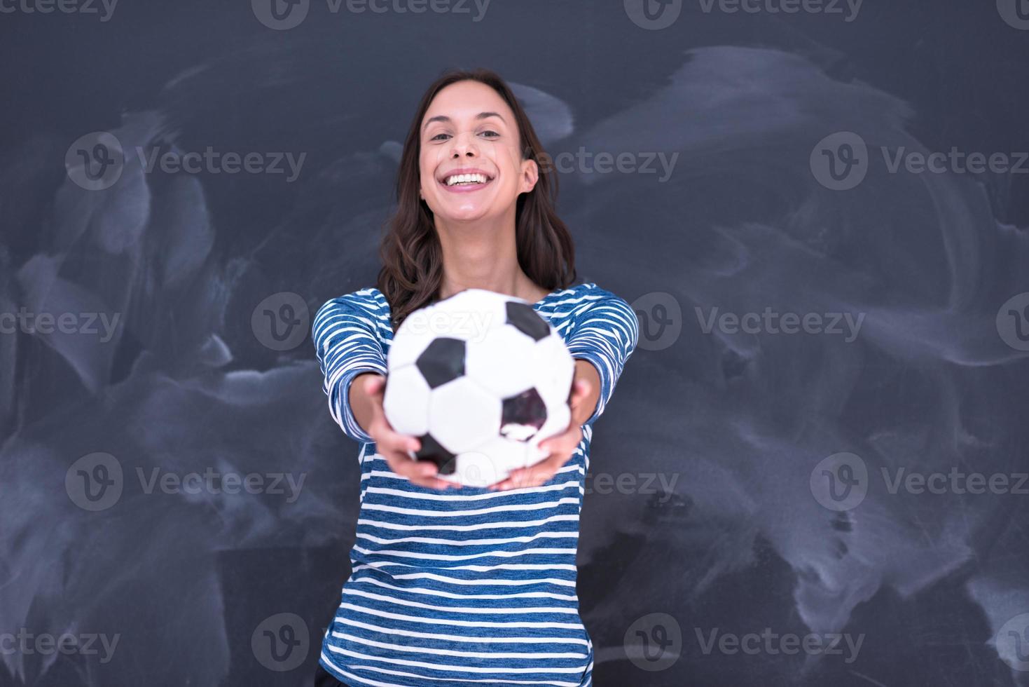 mulher segurando uma bola de futebol na frente da prancheta de giz foto