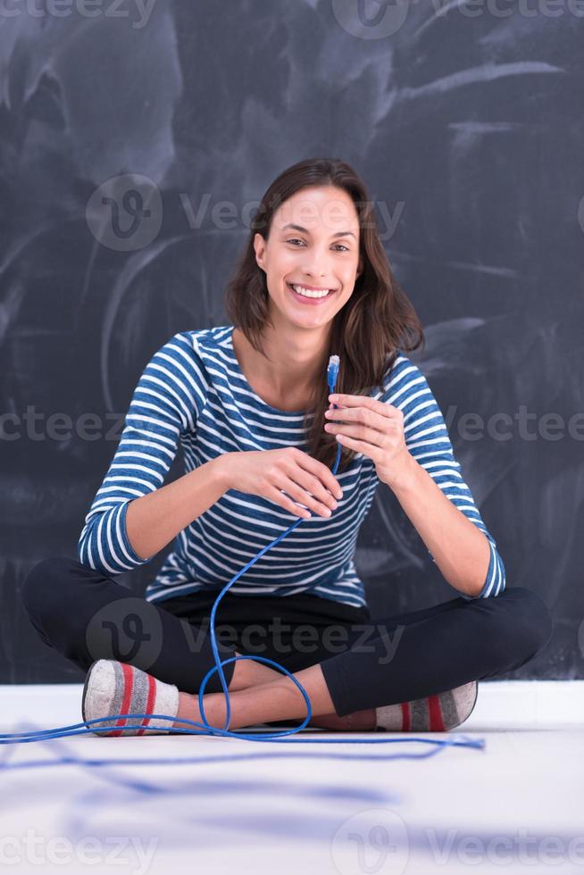 mulher segurando um cabo de internet na frente da prancheta de giz foto