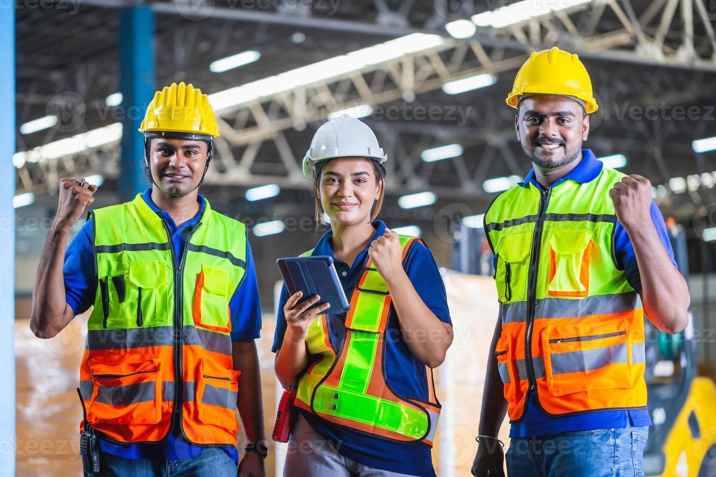 equipe de trabalhadores de armazém bem-sucedida socando o ar em comemoração, trabalhadores manuais comemorando o sucesso no armazém da fábrica foto