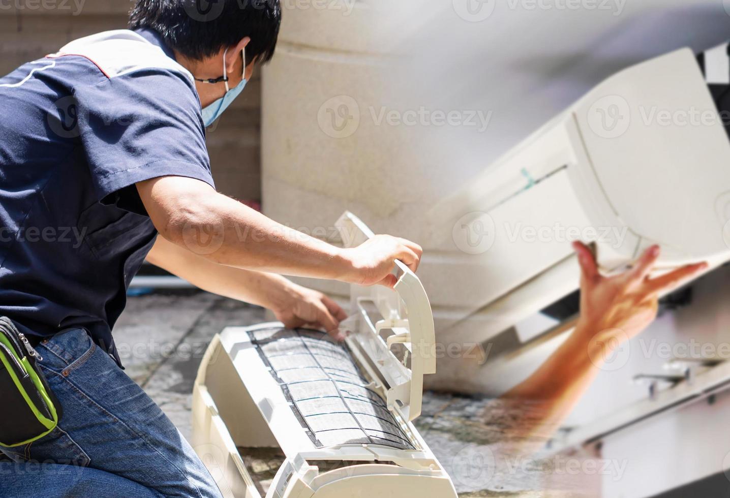 técnico masculino limpando ar condicionado dentro de casa, reparador lavando compartimentos sujos condicionador de ar, conceitos de manutenção e reparação foto