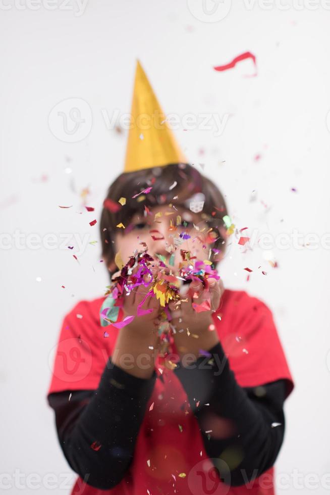 criança soprando confete foto