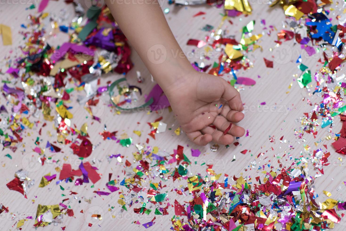 mão infantil com confete no fundo foto