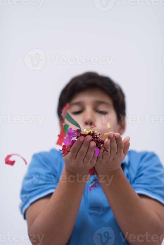 criança soprando confete foto