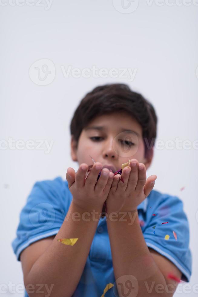 criança soprando confete foto