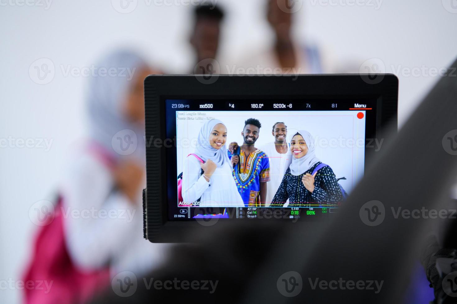 cinegrafista em estúdio branco gravando vídeo na câmera profissional foto