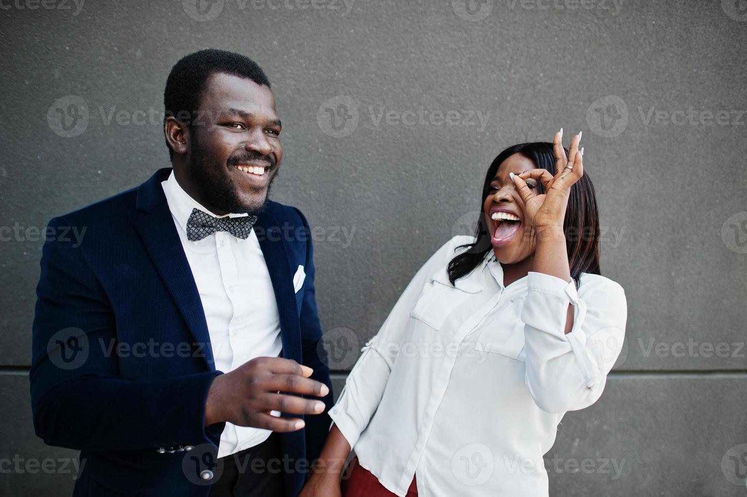 elegante casal americano africano com roupa formal. casal romântico apaixonado namoro. eles mostram os dedos ok. foto