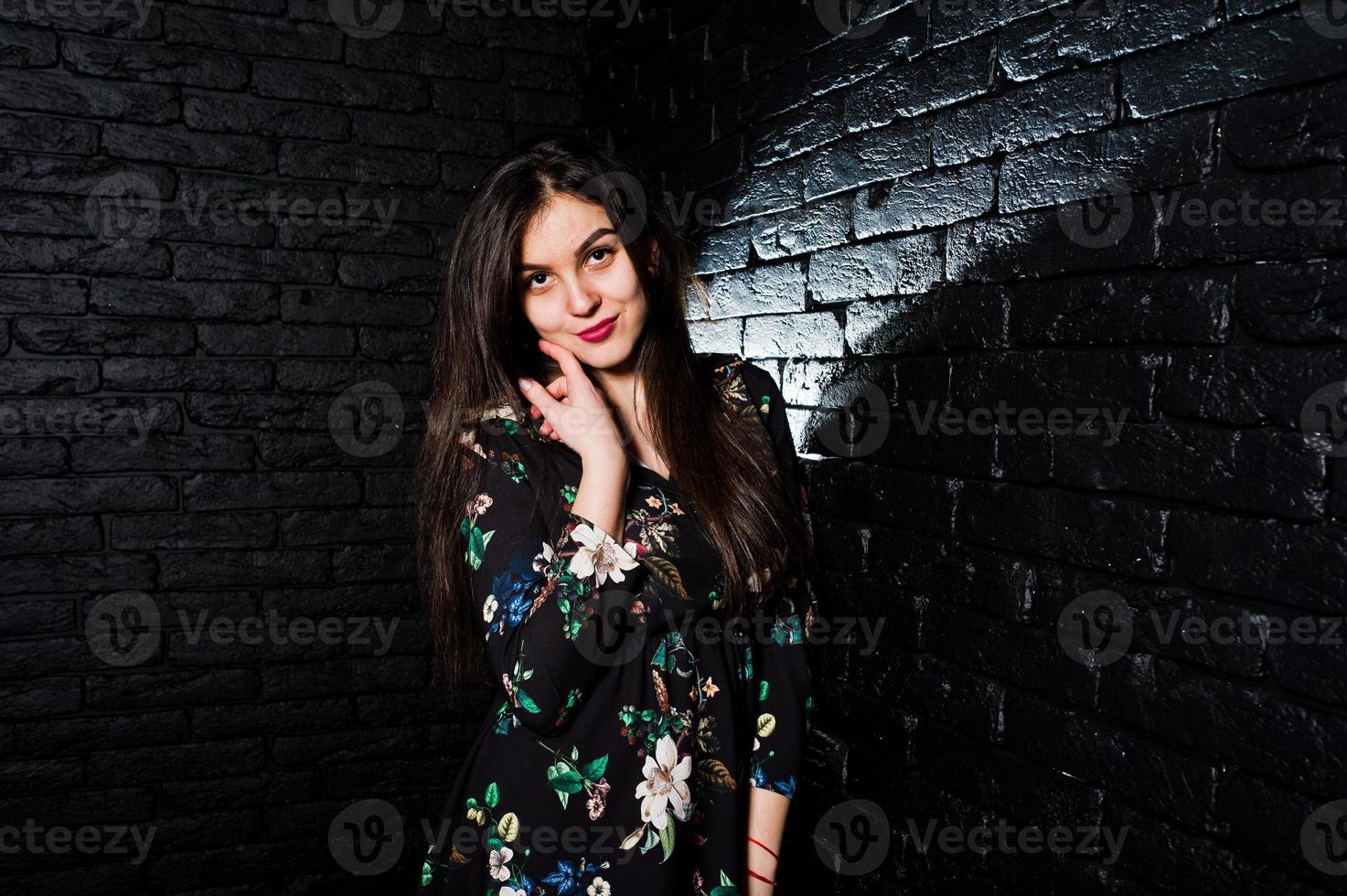 retrato de uma jovem fabulosa em vestido floral no estúdio escuro. foto