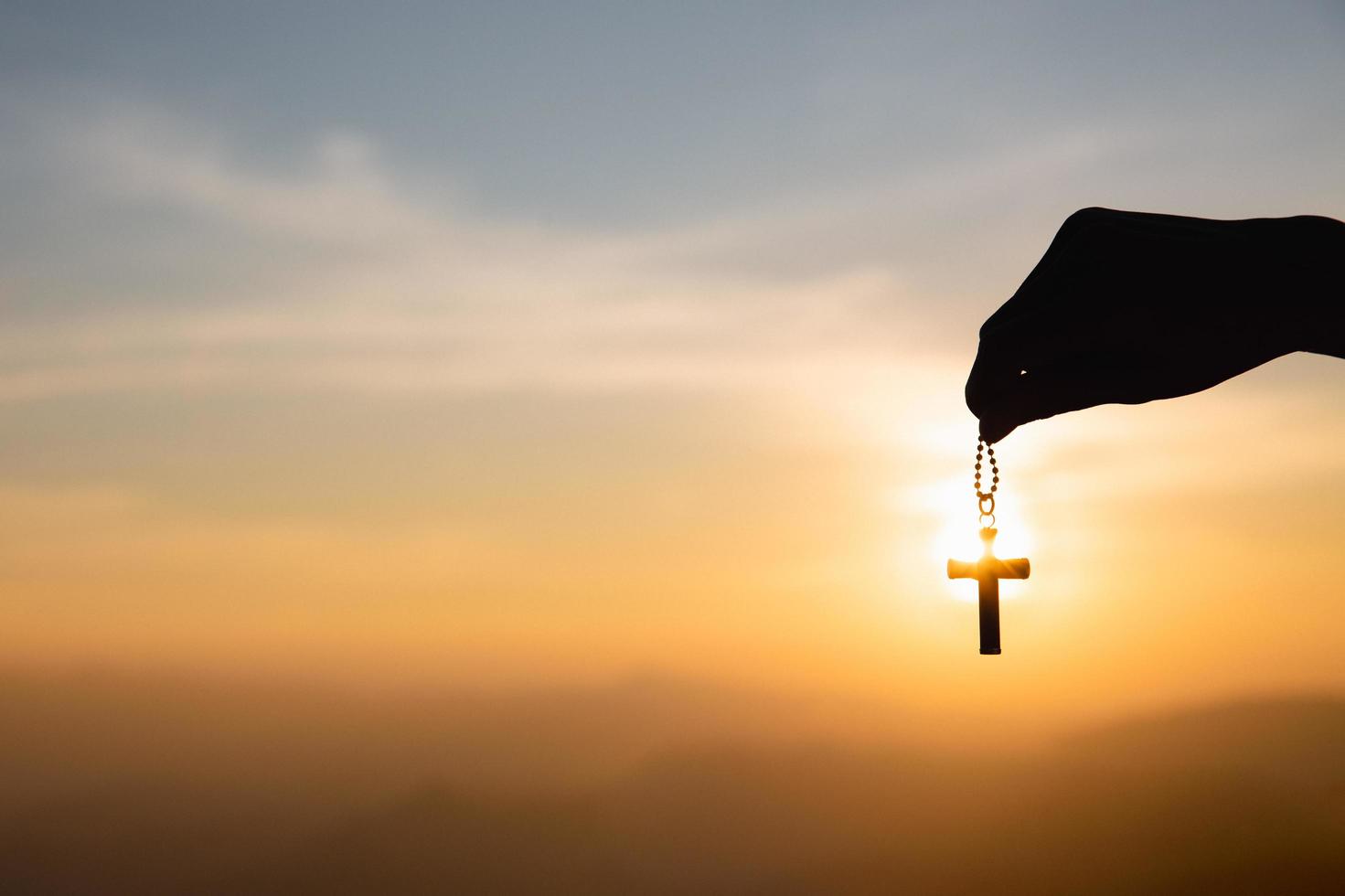 conceito religioso, mão humana segurando um colar de cruz cristã. jesus cristo cruz conceito de ressurreição de páscoa foto