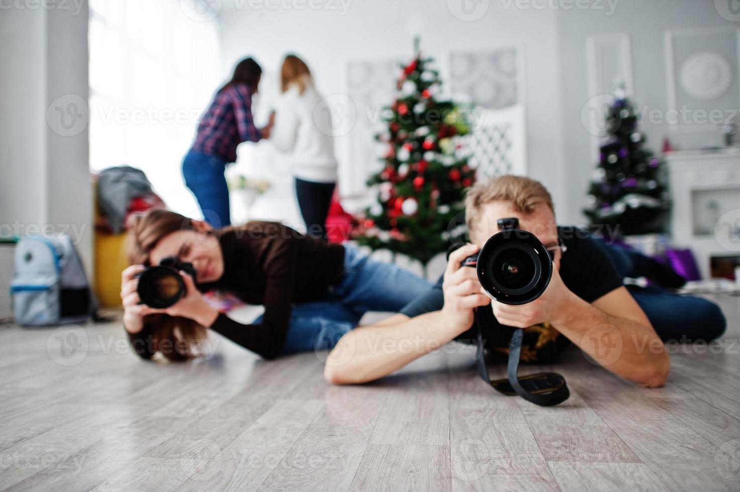 a equipe de dois fotógrafos está deitada no chão e fotografando em estúdio. foto