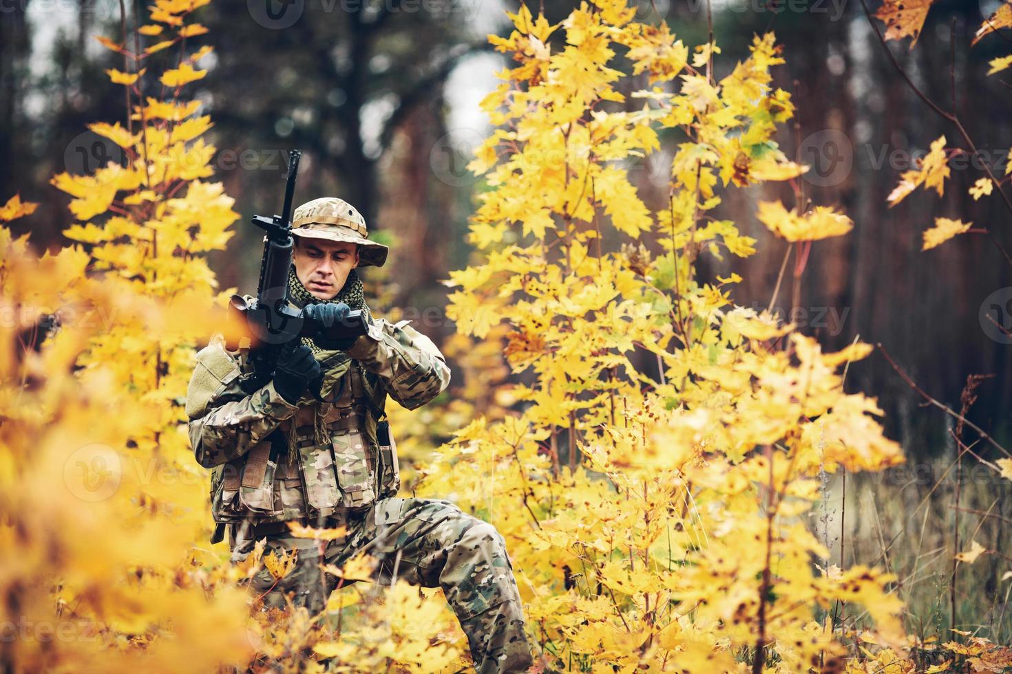 soldado com rifle na floresta foto