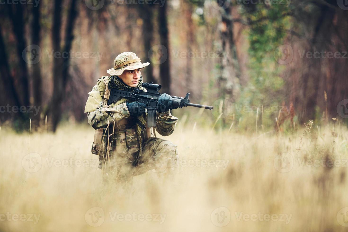 soldado com rifle na floresta foto