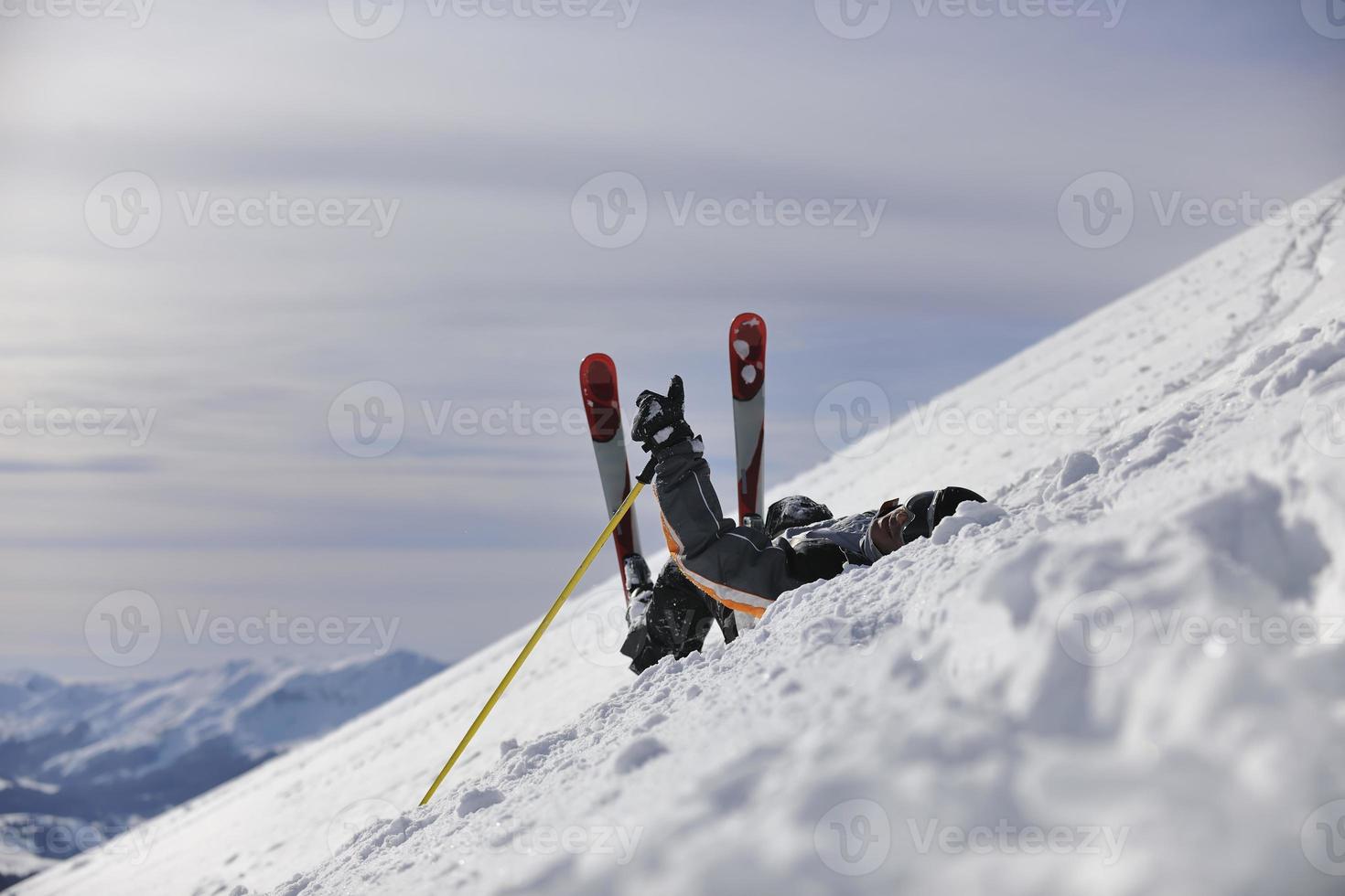 jovem esquiador relaxante no lindo dia ensolarado de inverno foto