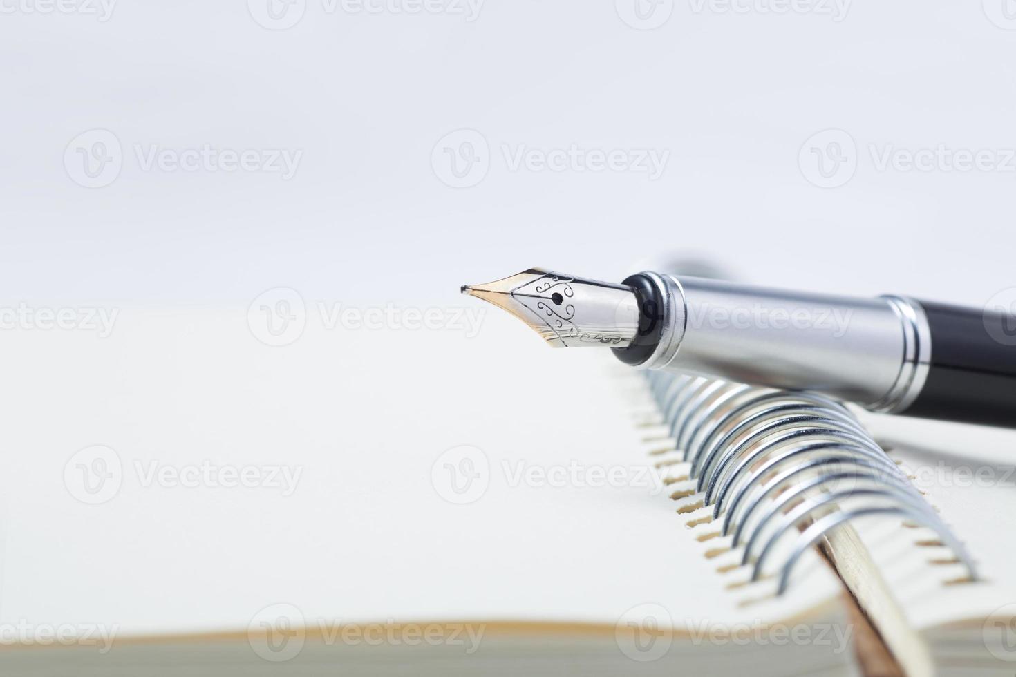caneta-tinteiro no caderno foto