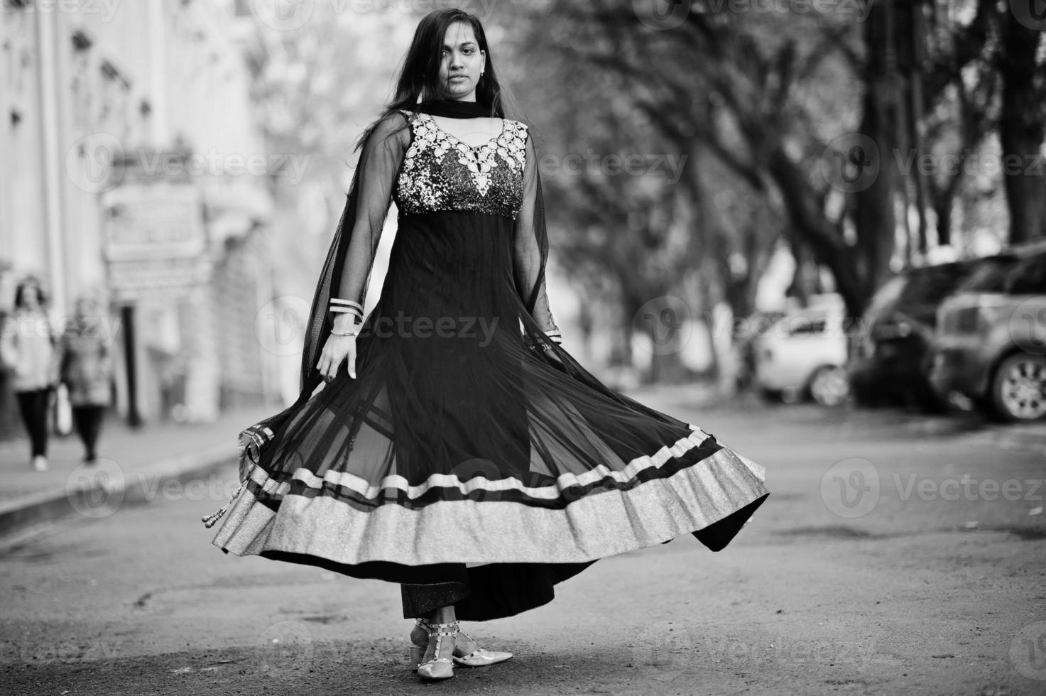 menina bonita indiana no vestido preto saree posou ao ar livre na rua outono. foto
