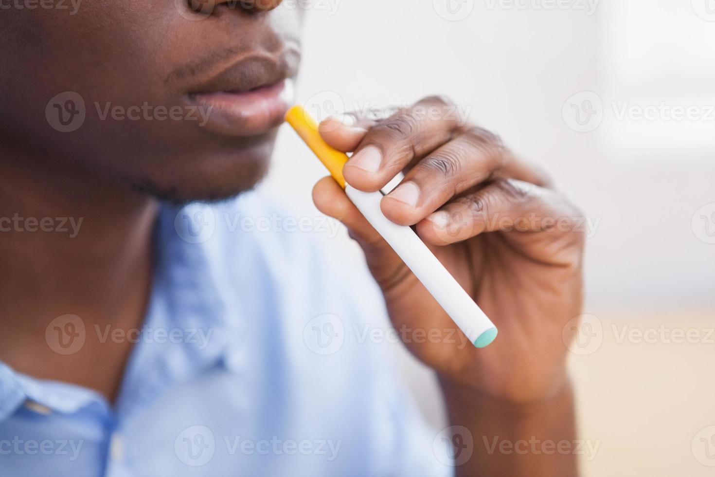 empresário, fumando um cigarro eletrônico foto