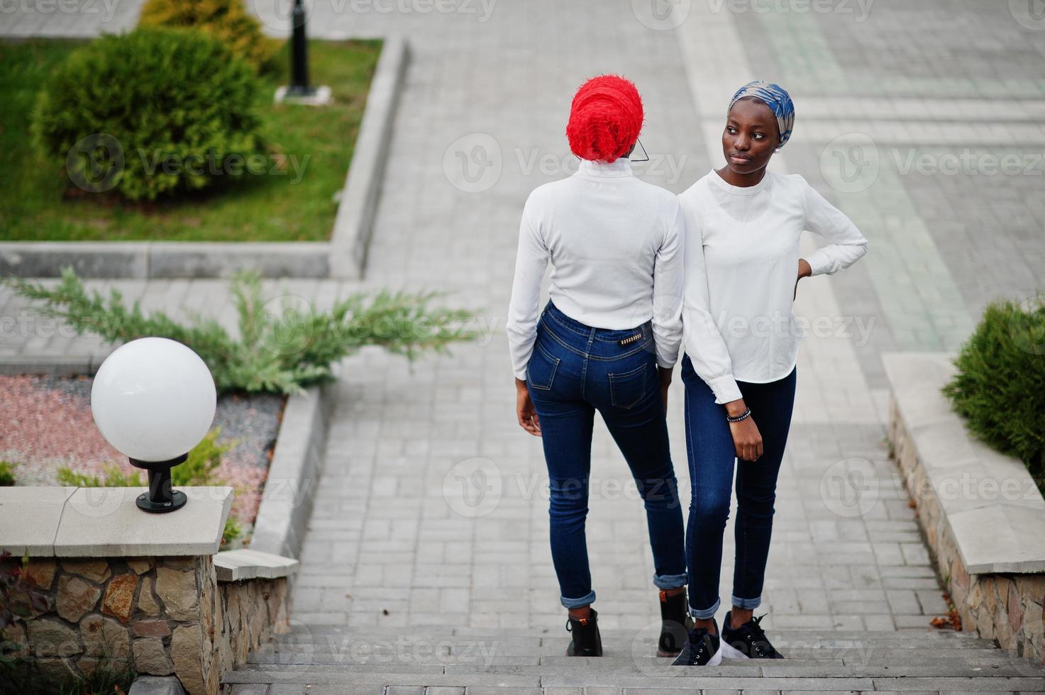 duas jovens muçulmanas africanas elegantes, atraentes, altas e magras no lenço de cabeça hijab ou turbante posaram juntos. foto