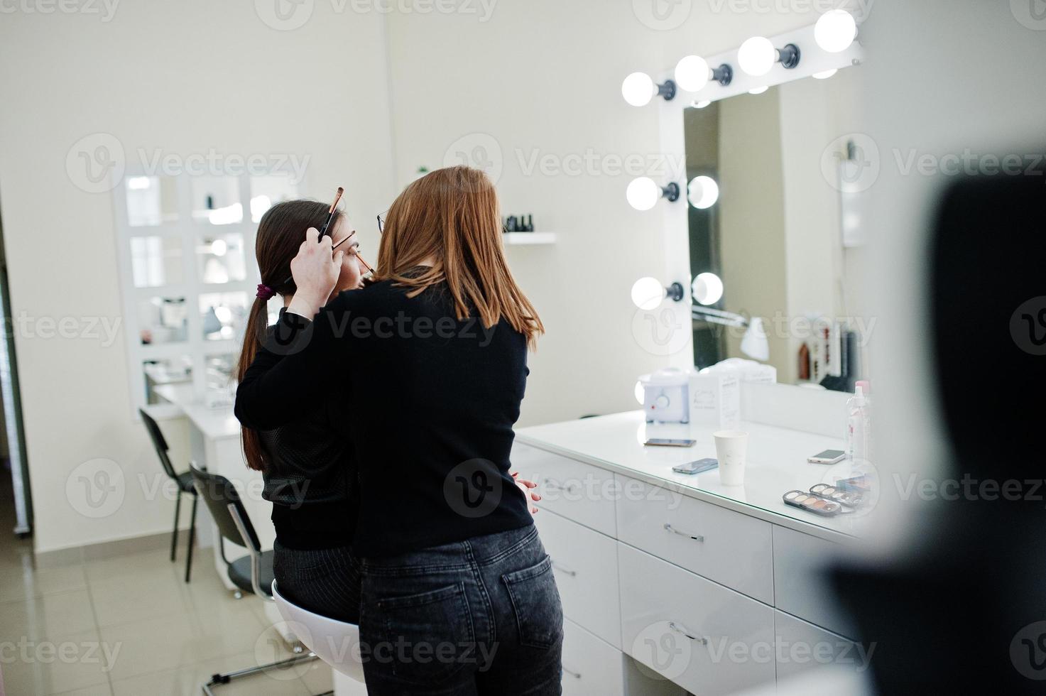 maquiadora trabalha em seu salão de beleza. mulher aplicando pelo mestre de maquiagem profissional. conceito de clube de beleza. foto