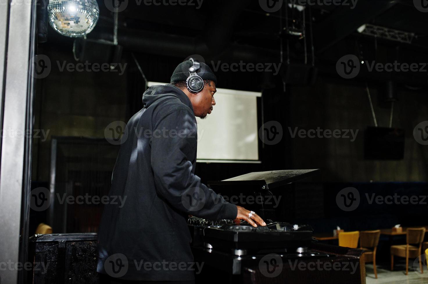 DJ afro-americano toca música em decks na boate. foto