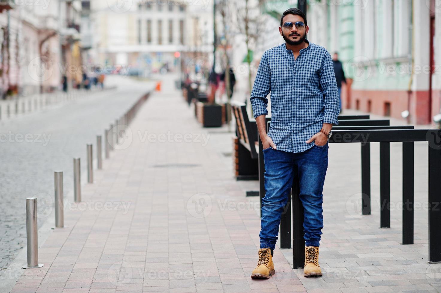 homem modelo de barba indiana elegante em roupas casuais posou ao ar livre na rua da índia. foto