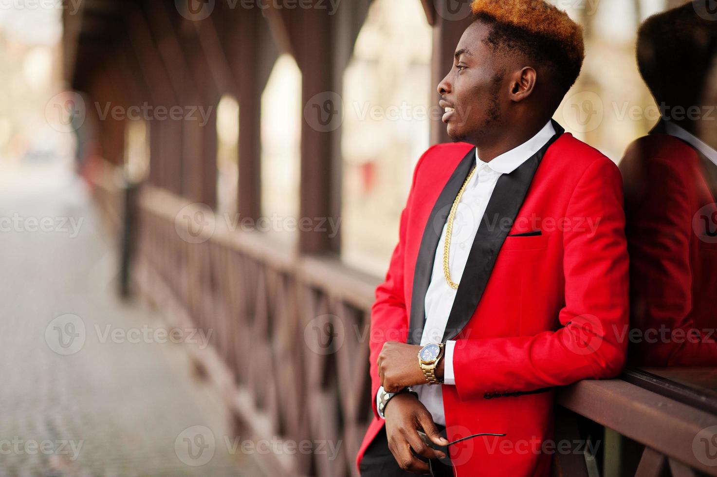 modelo de homem afro-americano de moda no terno vermelho, com cabelo de destaques posado na rua. foto