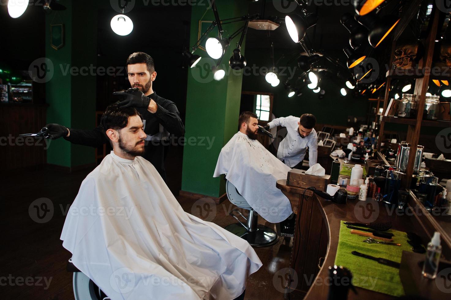 homem barbudo bonito na barbearia, barbeiro no trabalho. foto