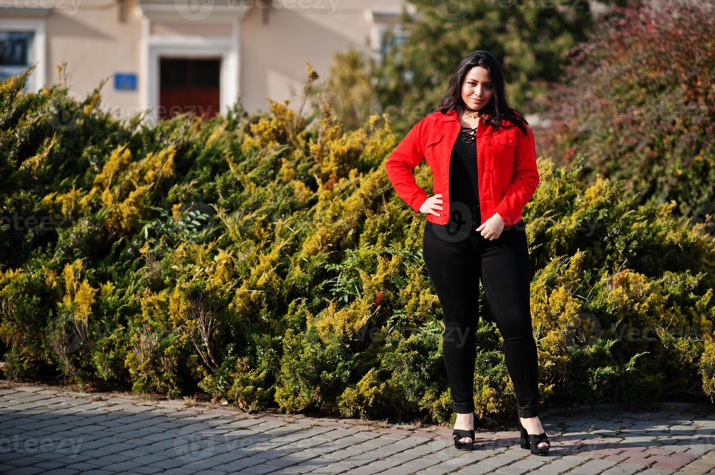 menina bonita modelo latino do Equador veste jaqueta preta e vermelha posada na rua. foto