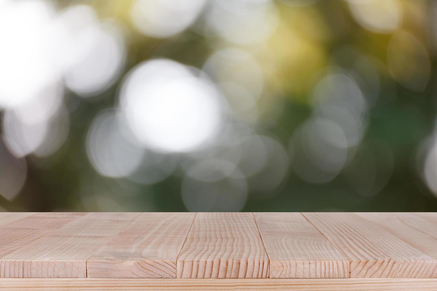 tampo de mesa de madeira em fundo verde bokeh - pode ser usado para montagem ou exibir seus produtos foto