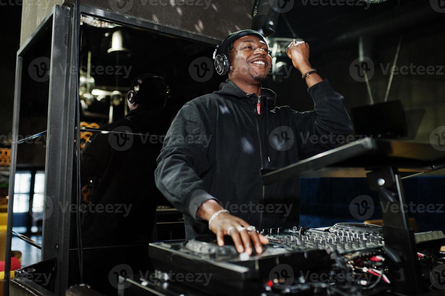 DJ afro-americano toca música em decks na boate. foto