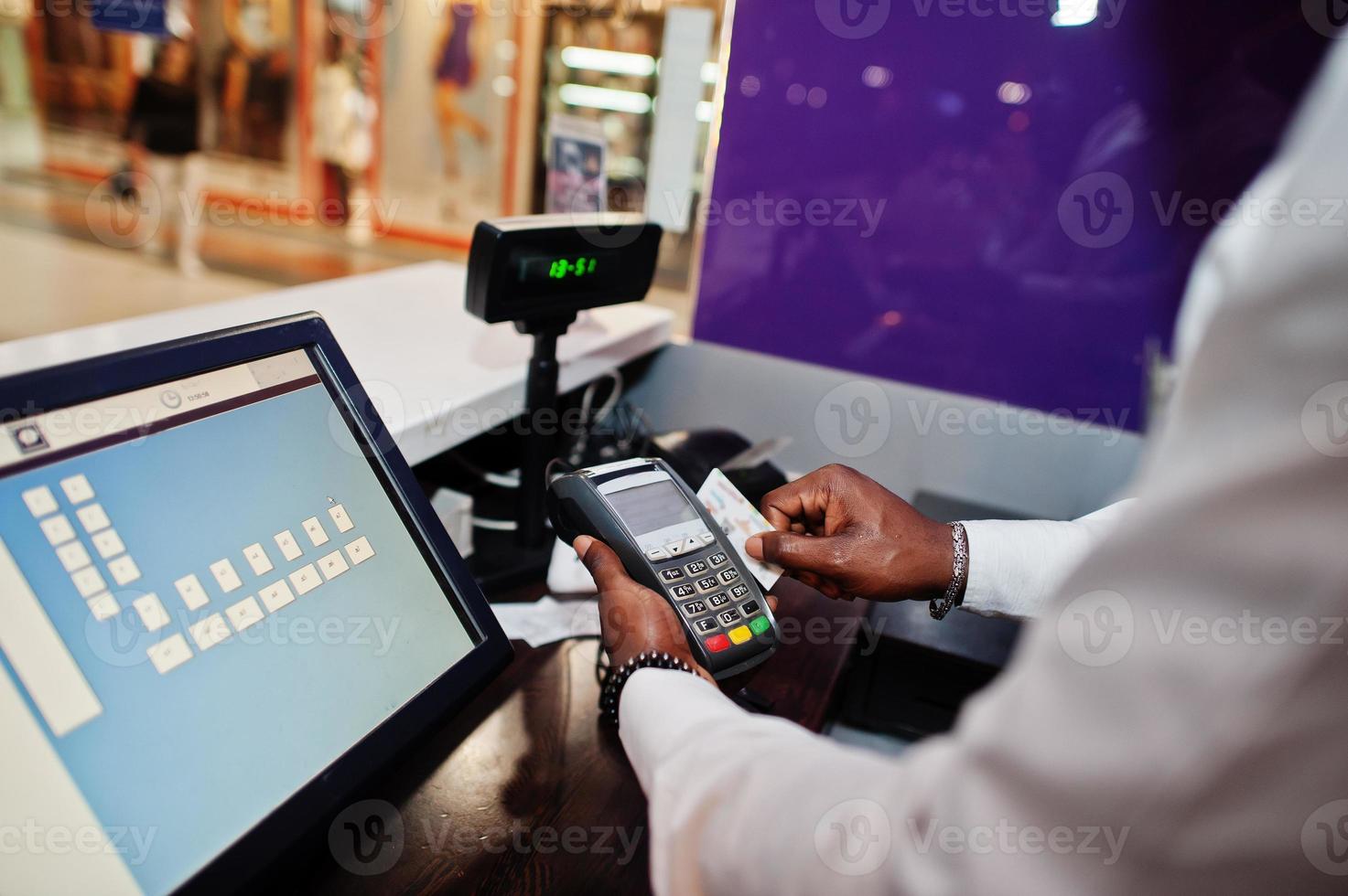 barman americano africano no bar usa um terminal de cartão de crédito no caixa. foto