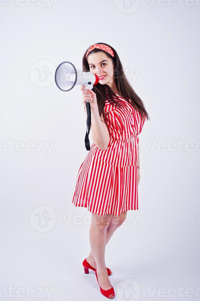 retrato de uma jovem mulher bonita de vestido vermelho falando no megafone. foto