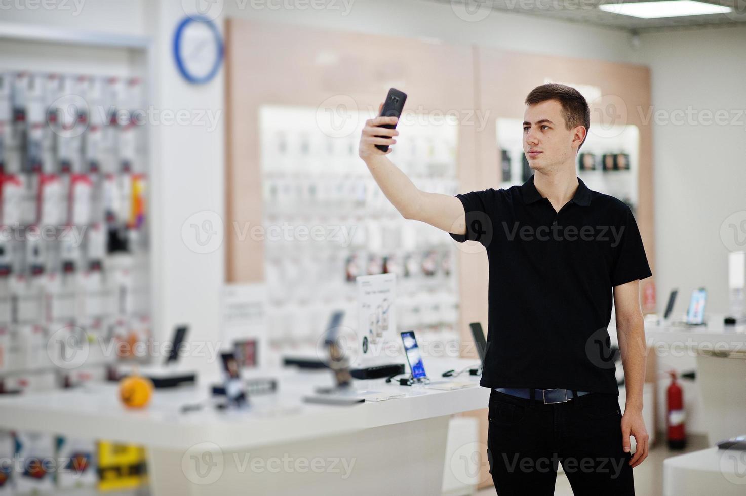 vendedor homem consultor profissional de telefonia móvel em loja de tecnologia ou loja. foto