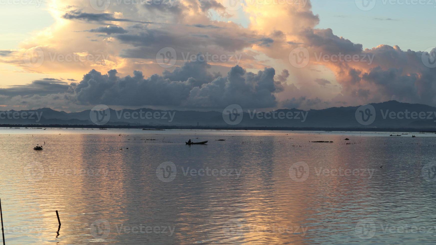 pescador em seu barco ao pôr do sol. barco de pescadores ao pôr do sol foto